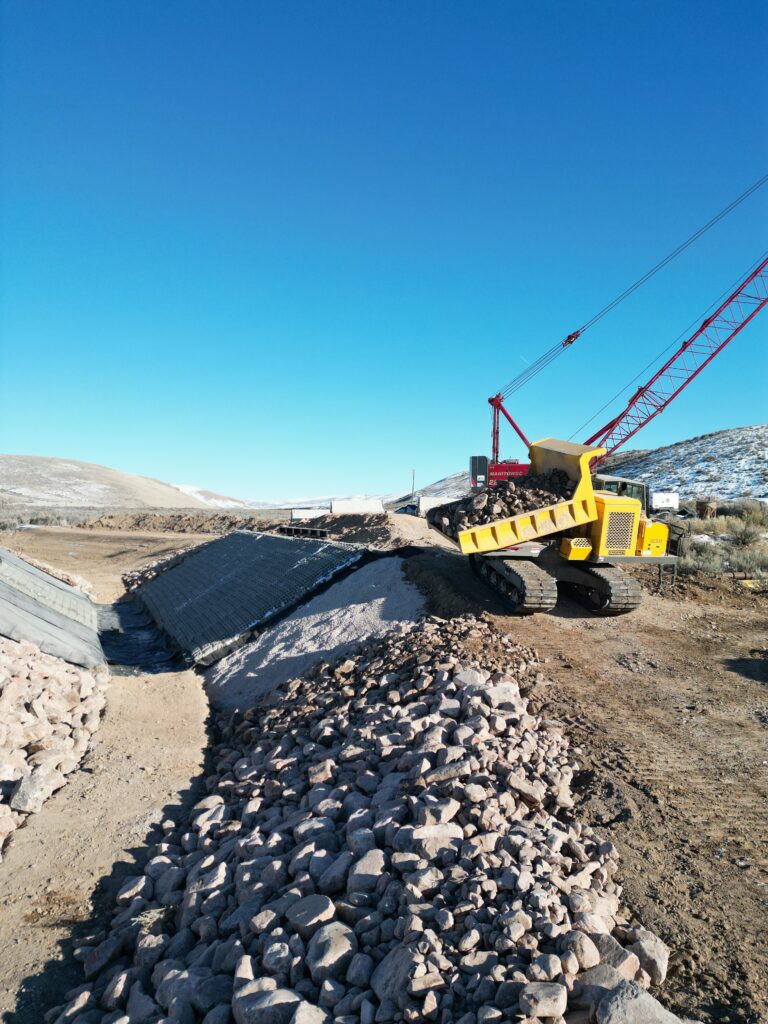 Heavy machinery working on a job site with mountains in the background in Wyoming, USA.
