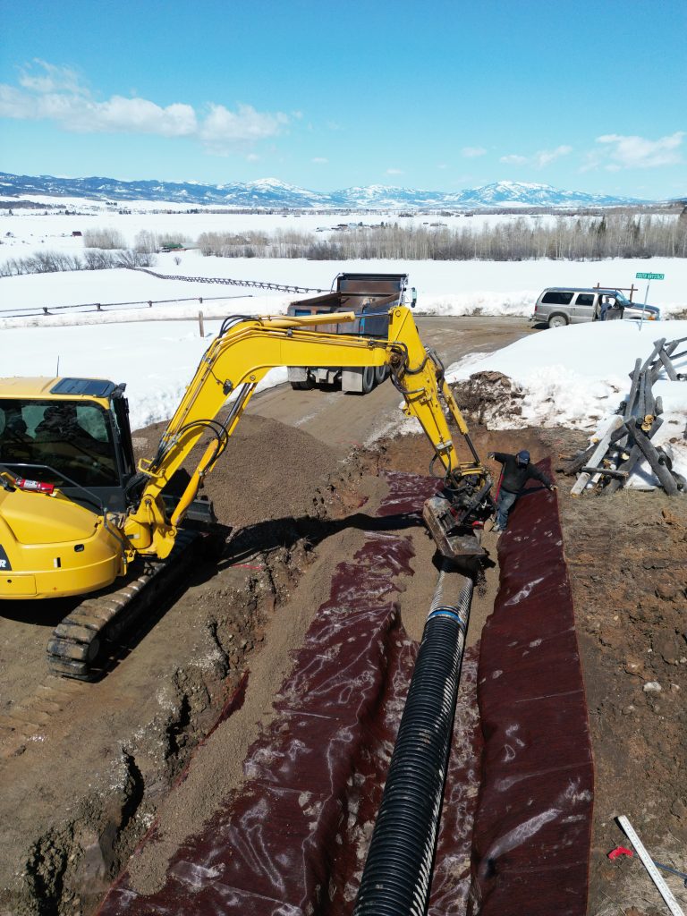 Commercial underground utility installation in Alpine WY using excavator and trenching equipment